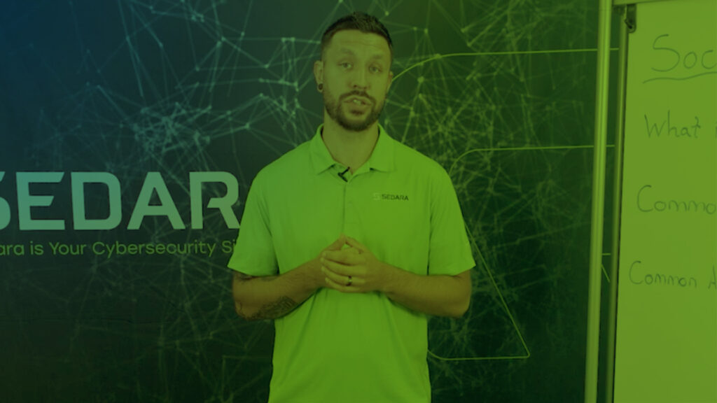 Sedara Team Member standing in front of a whiteboard, ready to present or discuss cybersecurity strategies.